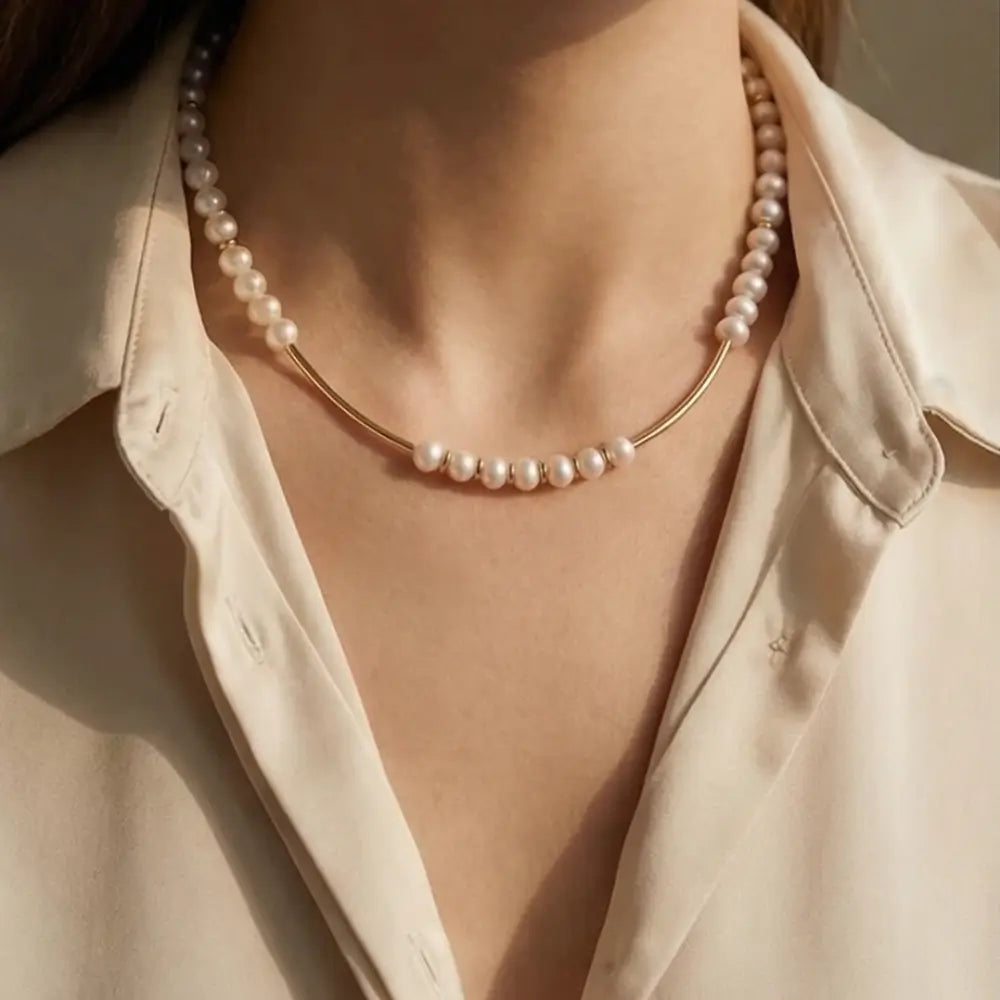 woman wearing minimalist pearl necklace with gold bar accents elegant design